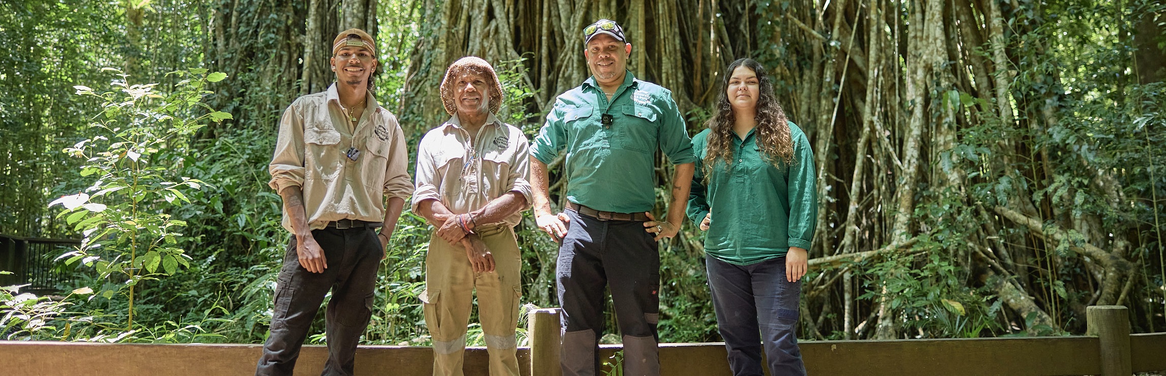 Rainforest to Bush Cultural Experiences employees Jahkoda Rosas, Ross Rosas, Allan Anderson, and Keoni McDowall standing in front of 500yr old Cathedral Fig Tree 3